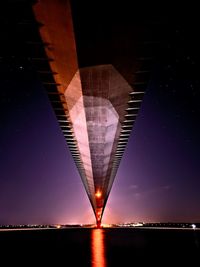 Low angle view of illuminated bridge against sky at night