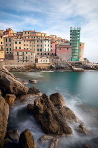 Scenic view of sea by buildings against sky