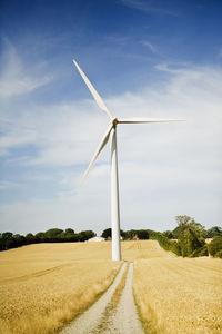 Windmill on field against sky