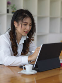 Smiling businesswoman using laptop in office