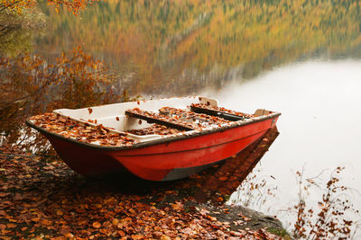 Traditional boat moored on lake during autumn