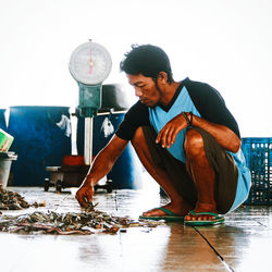 Young man with fish in container