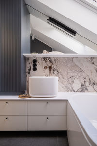 A bathroom with a sink and a bathtub under a skylight