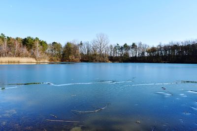 Scenic view of frozen lake against clear blue sky