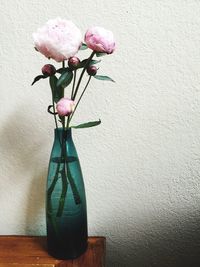 Close-up of flower vase on table against wall