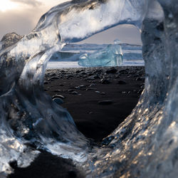 Sea seen through hole in ice at beach during winter