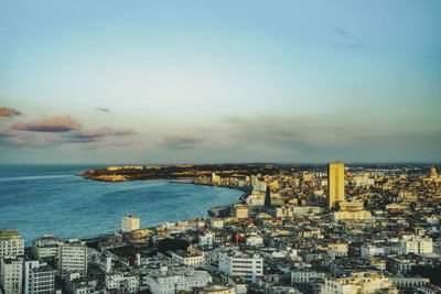 High angle view of townscape by sea against sky