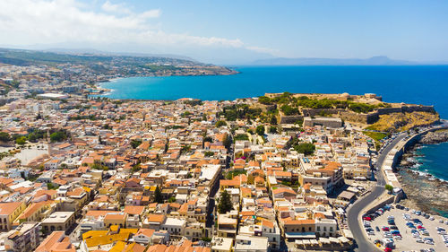 High angle view of townscape by sea against sky