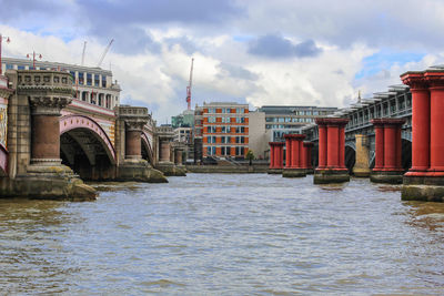 River by buildings against sky