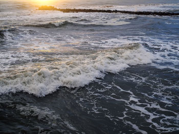 Close-up of wave on beach against sky