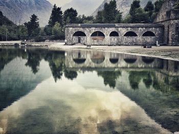 Reflection of bridge in lake against sky