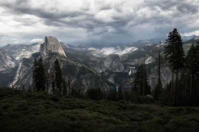 Scenic view of mountain range against cloudy sky