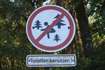 Close-up of road sign against trees