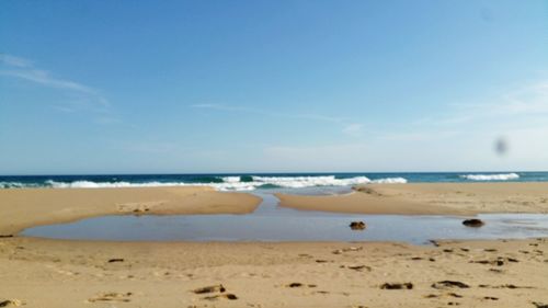 Scenic view of beach against blue sky