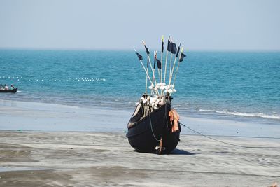 Boat on beach against clear sky