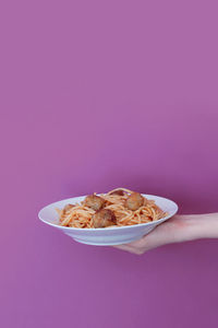 Close-up of hand holding ice cream in bowl