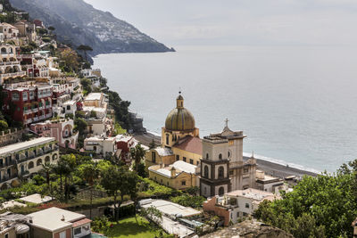 High angle view of townscape by sea against sky