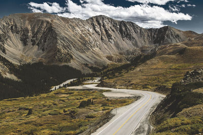 Road by mountain against sky