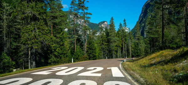 Road amidst trees against sky