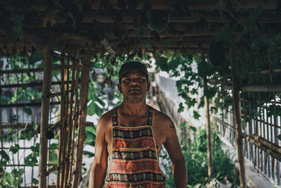 Portrait of young man standing against built structure