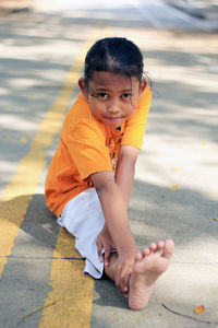 Portrait of girl doing splits on road