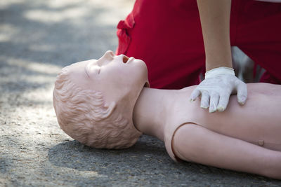 Midsection of paramedic performing cpr on dummy