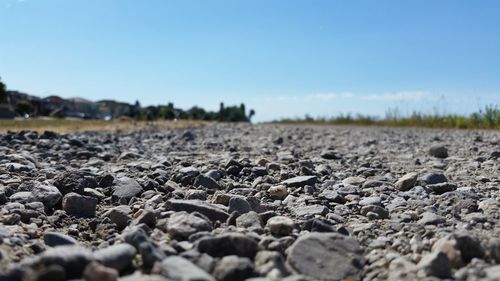 Surface level of pebbles against clear sky