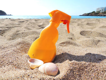 Close-up of toy on sand at beach against sky