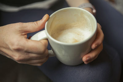 Close-up of hand holding coffee cup