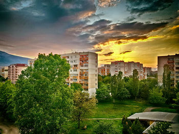 Buildings against cloudy sky at sunset