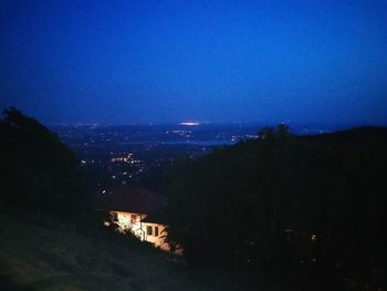 Illuminated cityscape against sky at night