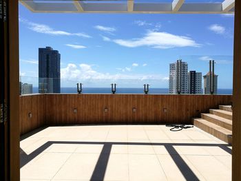 Modern buildings by swimming pool against sky