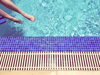 Low section of woman in swimming pool on sunny day