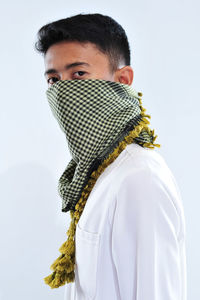 Portrait of young man standing against white background