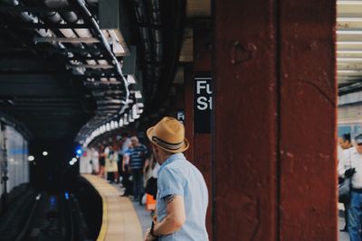 Rear view of man standing by subway station