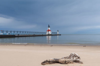 Lighthouse by sea against sky