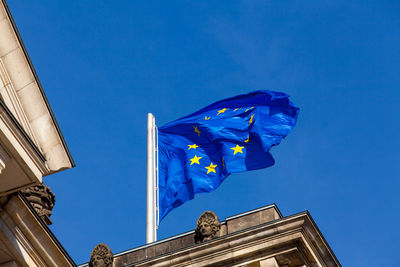 Low angle view of flag against blue sky