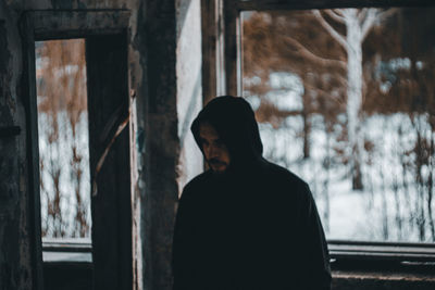 Portrait of man standing by window