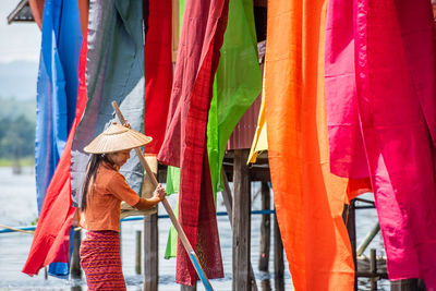 Midsection of woman holding multi colored umbrella