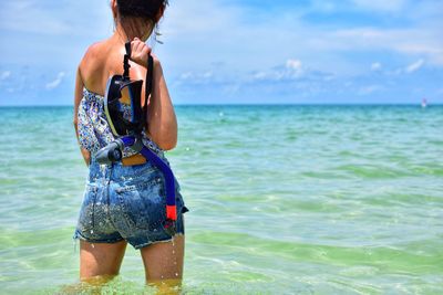 Rear view of woman standing on beach