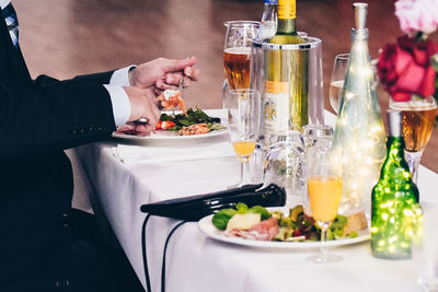 Midsection of man having food on table