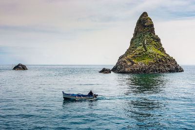 Man in boat on sea against sky