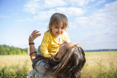 Portrait of boy smiling on field against sky