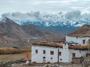 Houses on snowcapped mountain against sky