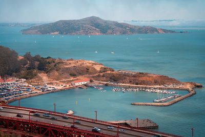 High angle view of city by sea against sky
