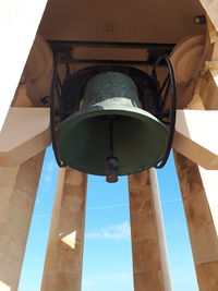 Low angle view of electric lamp against building