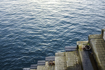 High angle view of steps by blue sea