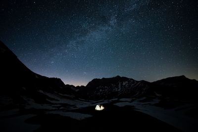 Scenic view of illuminated mountains against sky at night