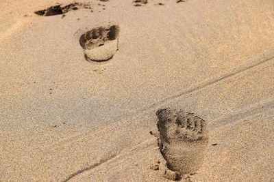 High angle view of footprints on sand at beach