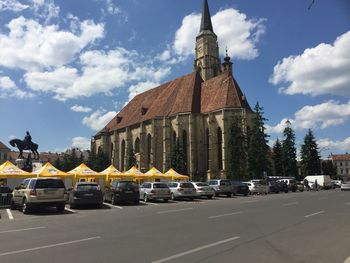 Cars on road in city against sky